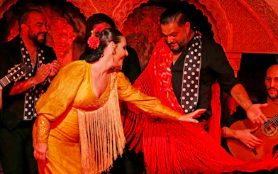 Flamenco dancers performing at Tablao Cordobes in vibrant costumes.