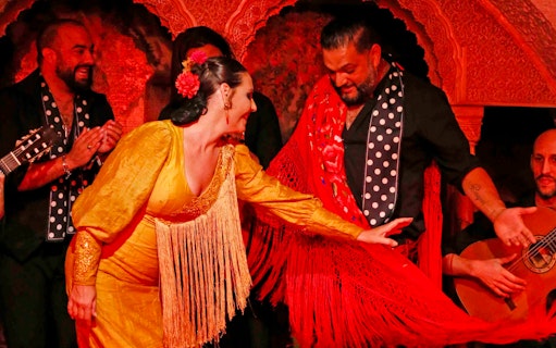 Flamenco dancers performing at Tablao Cordobes in vibrant costumes.