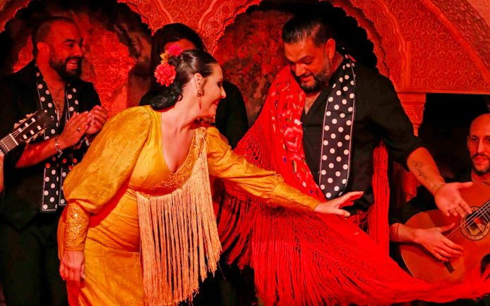 Flamenco dancers performing at Tablao Cordobes in vibrant costumes.