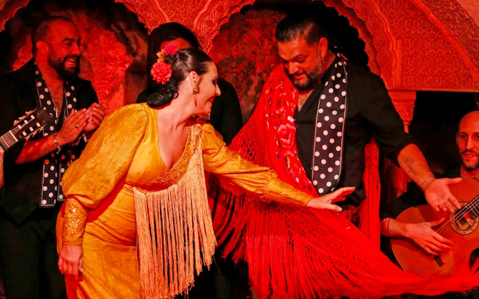 Flamenco dancers performing at Tablao Cordobes in vibrant costumes.