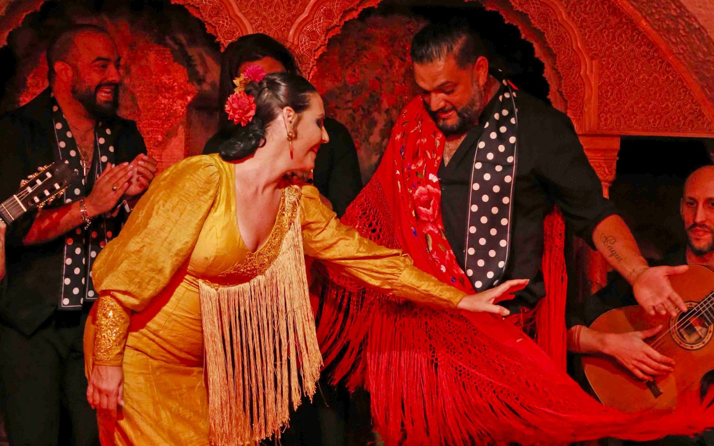 Flamenco dancers performing at Tablao Cordobes in vibrant costumes.
