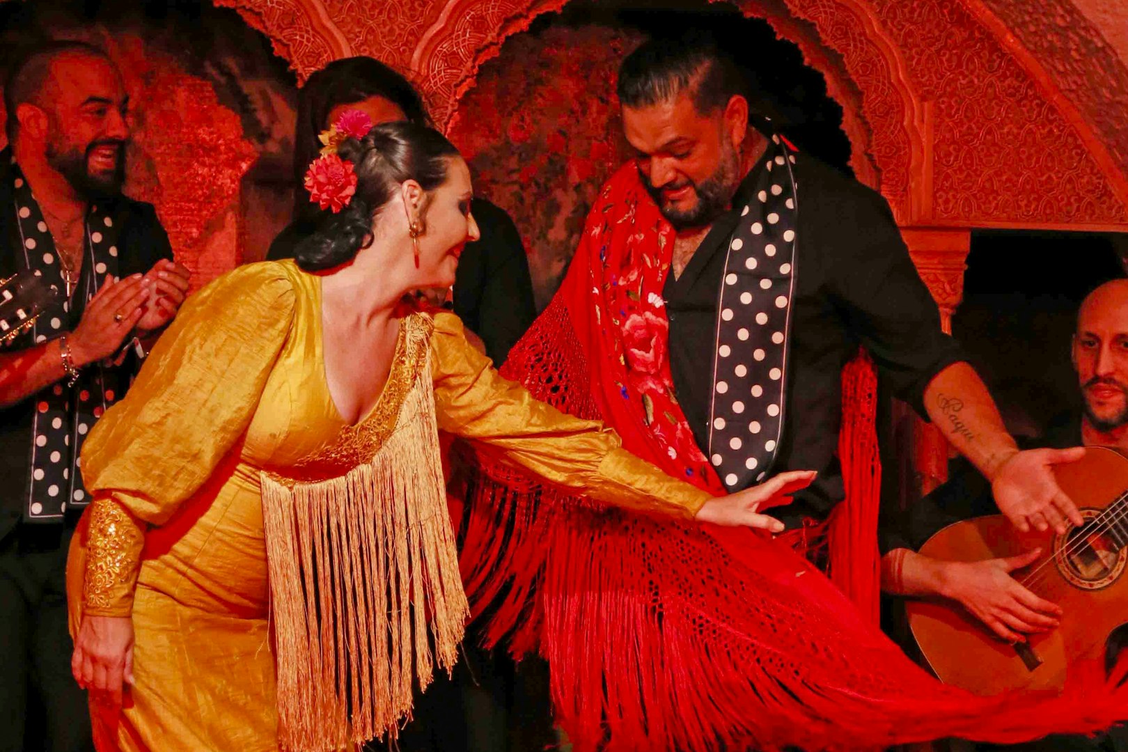 Flamenco dancers performing at Tablao Cordobes in vibrant costumes.