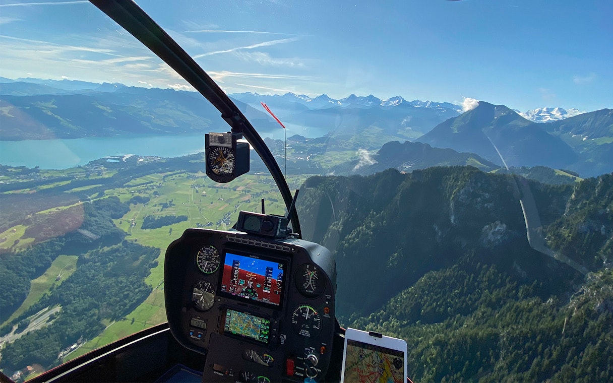Helicopter cockpit view over Stockhorn Mountain near Bern-Belp Airport.