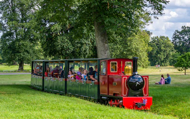 Toy train ride at Blenheim Palace with passengers enjoying the scenic park view.