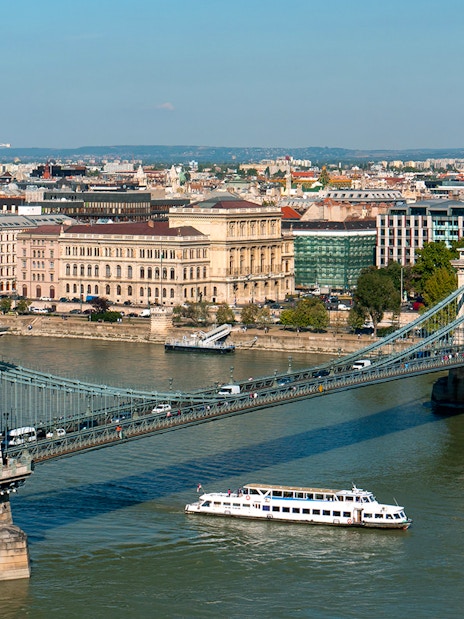 Cruise boat on Danube River passing under Chain Bridge in Budapest.