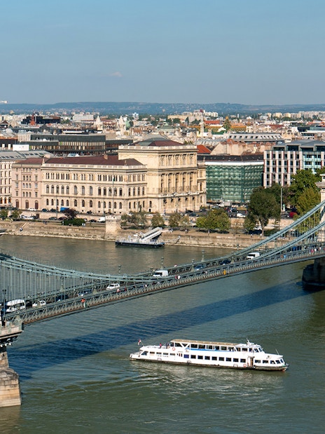 Cruise boat on Danube River passing under Chain Bridge in Budapest.