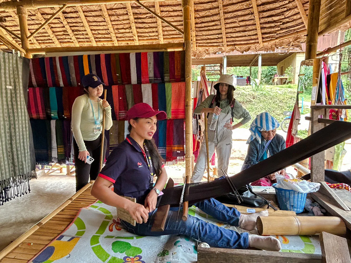 Guided trek group at a traditional weaving demonstration in Doi Inthanon, Chiang Mai.