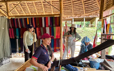 Guided trek group at a traditional weaving demonstration in Doi Inthanon, Chiang Mai.