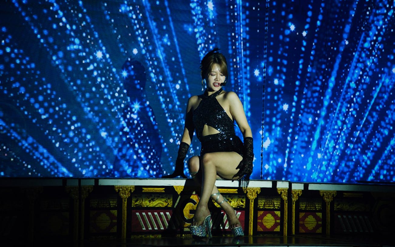 Performer on stage during Girls Night Meet&Greet Live Show with blue light backdrop.