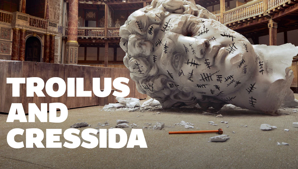 Giant head sculpture with tally marks in a theater setting, Troilus & Cressida.