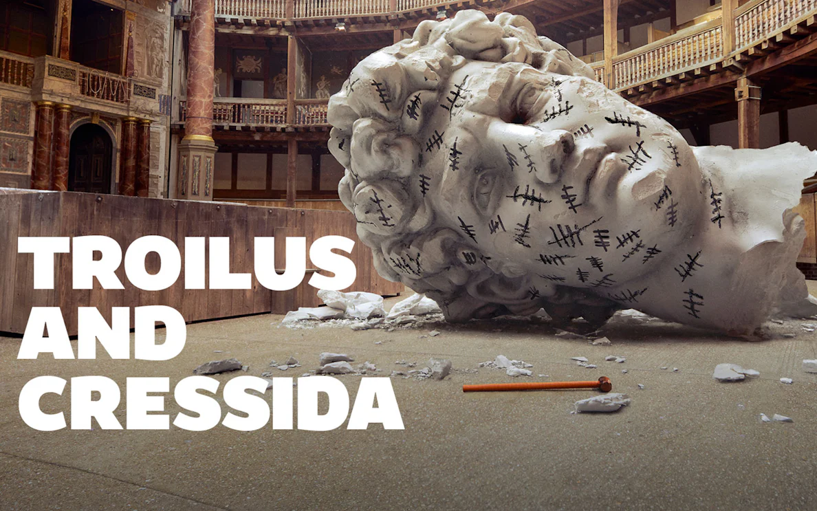 Giant head sculpture with tally marks in a theater setting, Troilus & Cressida.