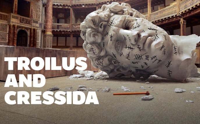 Giant head sculpture with tally marks in a theater setting, Troilus & Cressida.