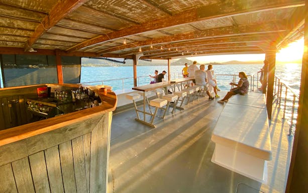 Sundowner cruise bar with people enjoying sunset views at Airlie Beach.