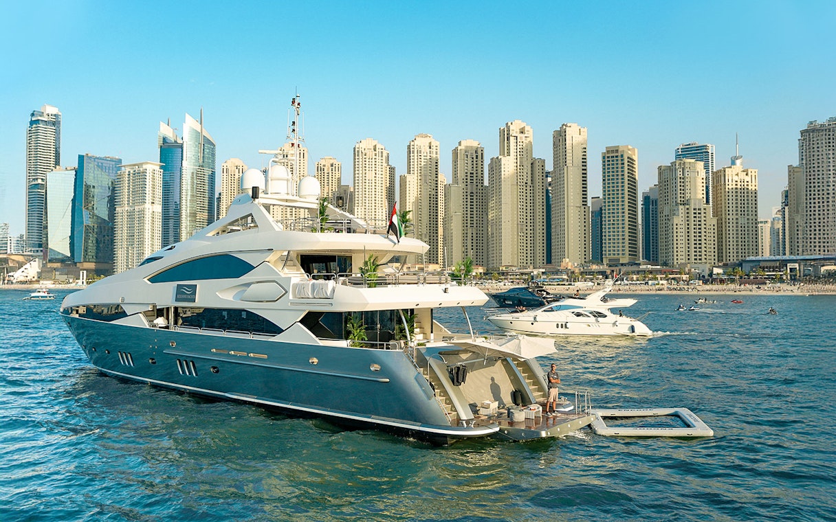 Superyacht on Dubai Marina with city skyline, offering gourmet dining and live music experience.