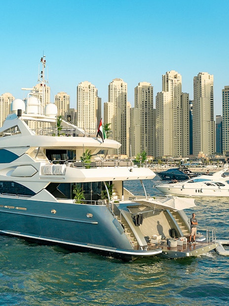 Superyacht on Dubai Marina with city skyline, offering gourmet dining and live music experience.