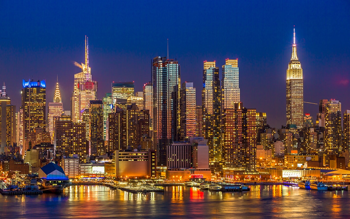 Manhattan skyline at night with illuminated midtown buildings, New York City.