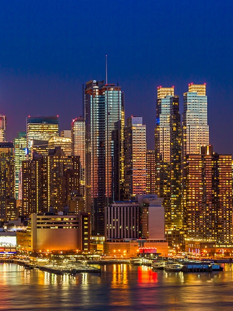 Manhattan skyline at night with illuminated midtown buildings, New York City.