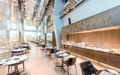 Al Maha Lounge dining area with buffet at Doha Hamad International Airport.