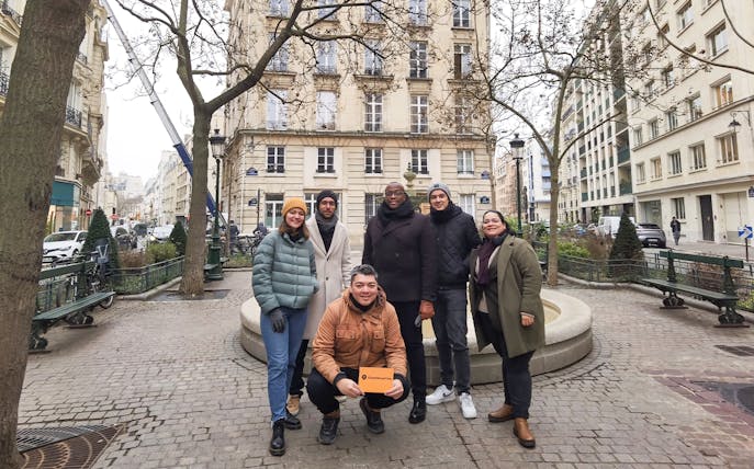 Group of tourists on the Emily in Paris Selfie Tour in a Parisian street.