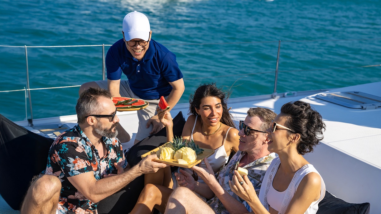 Tourists enjoying fruit snacks on a boat in Tenerife.