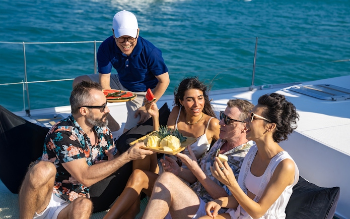 Tourists enjoying fruit snacks on a boat in Tenerife.