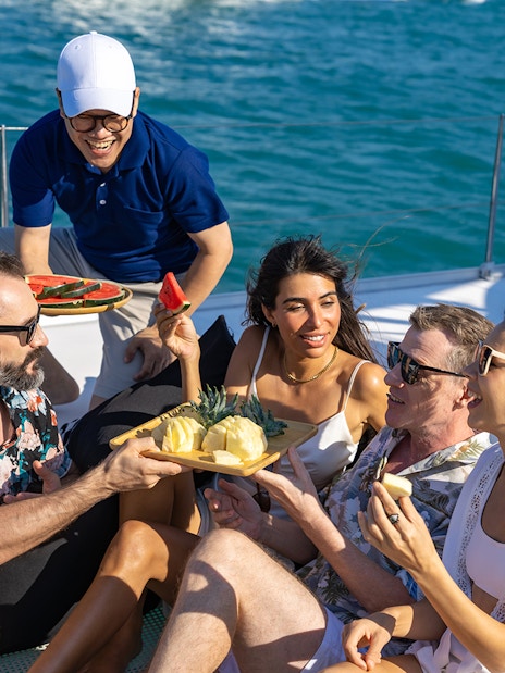 Tourists enjoying fruit snacks on a boat in Tenerife.