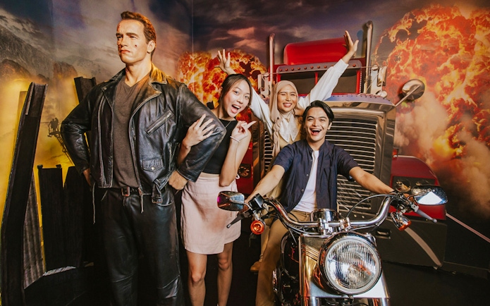 Wax figure of Terminator at Madame Tussauds Singapore with visitors posing nearby.