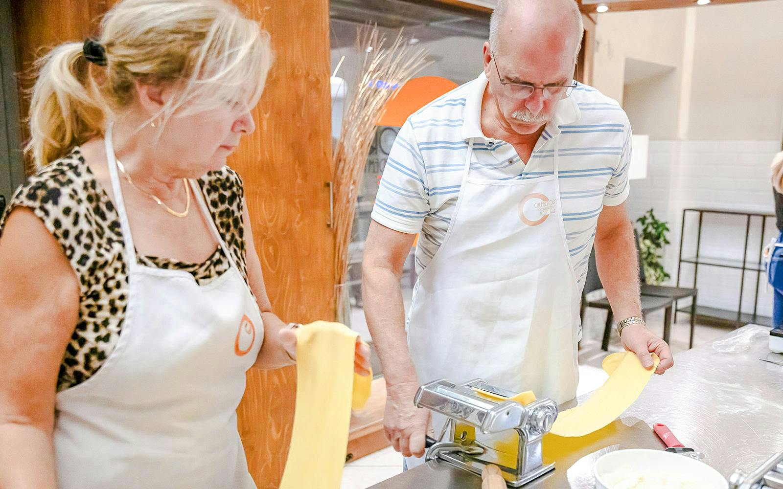 Couple making pasta in a small group cooking class in Florence.
