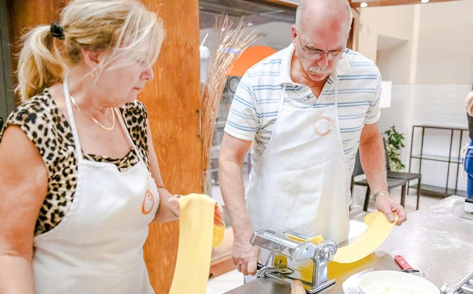 Couple making pasta in a small group cooking class in Florence.