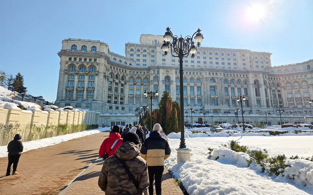Visitors walking towards the Palace of Parliament in Bucharest, Romania.