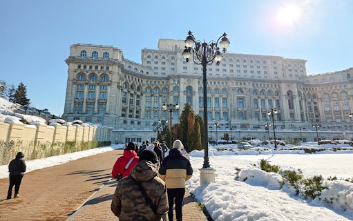 Visitors walking towards the Palace of Parliament in Bucharest, Romania.