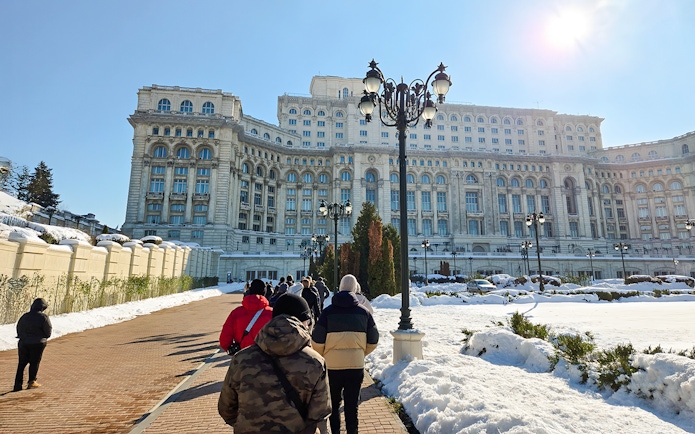 Visitors walking towards the Palace of Parliament in Bucharest, Romania.
