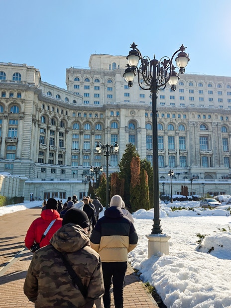 Visitors walking towards the Palace of Parliament in Bucharest, Romania.
