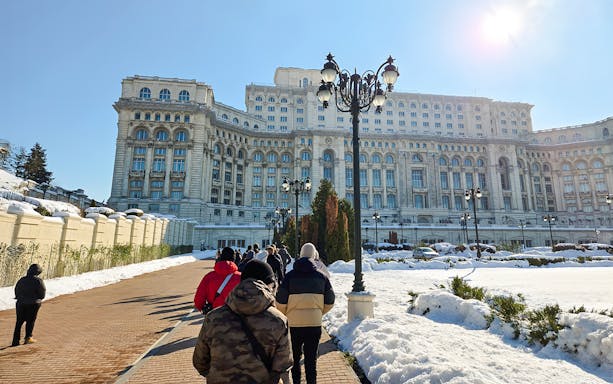 Visitors walking towards the Palace of Parliament in Bucharest, Romania.
