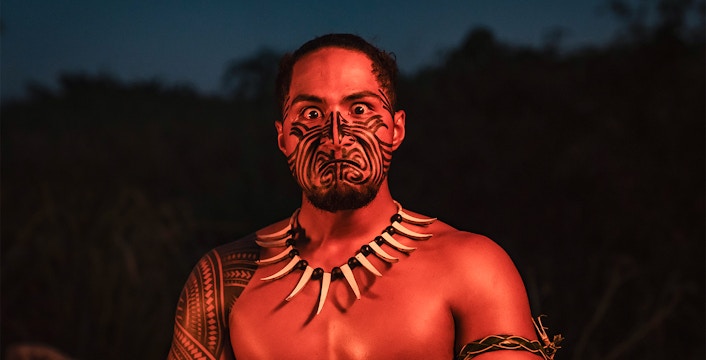Mauka Warriors performer with traditional Polynesian face tattoo in cultural dance, Hawaii.
