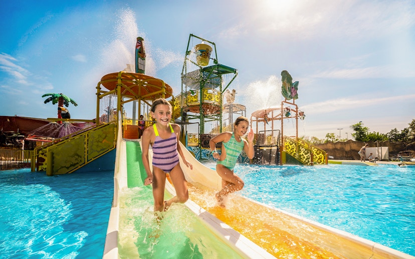 Children enjoying a water slide at Isla Mágica, Seville.