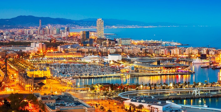 Monaco skyline at night with illuminated harbor and cityscape.