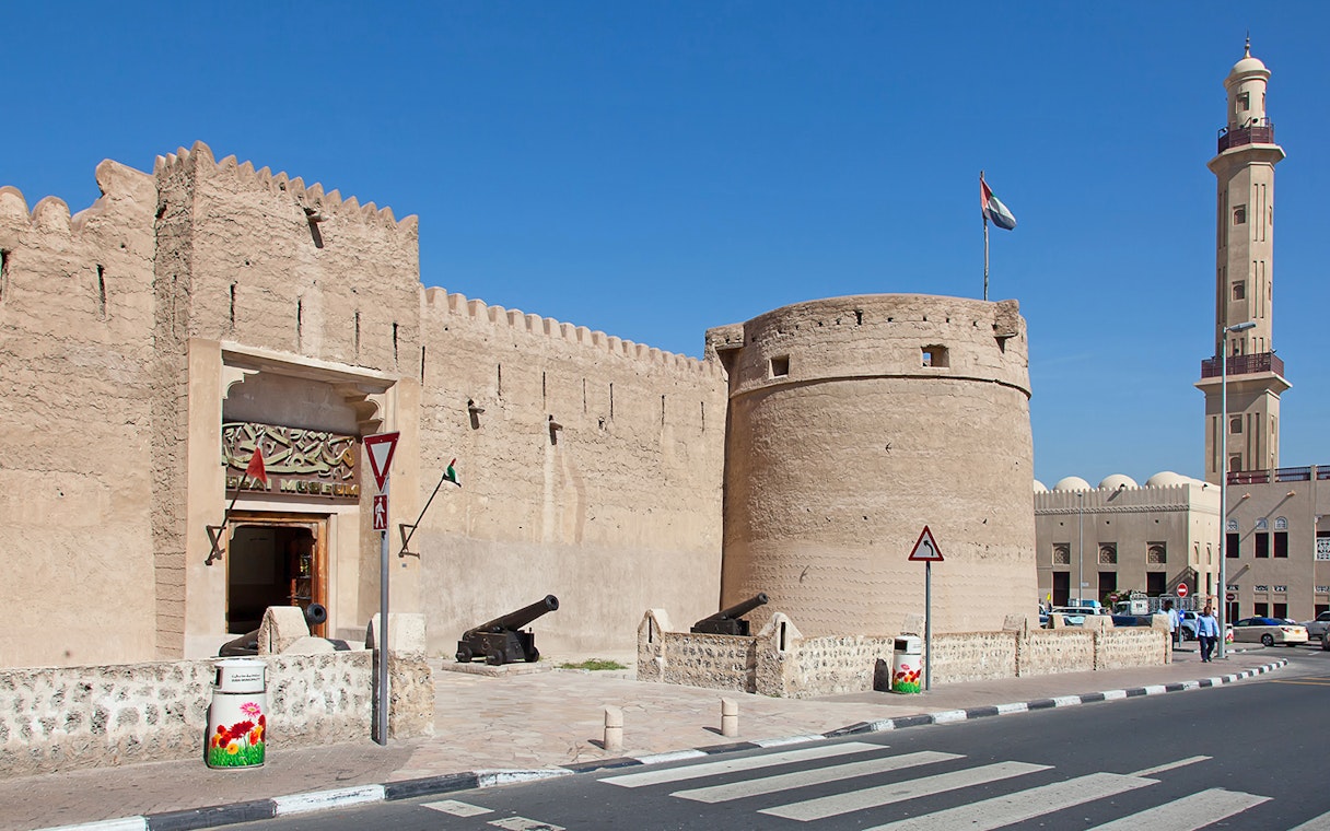 Dubai Museum entrance with historic fort walls and cannons, UAE.