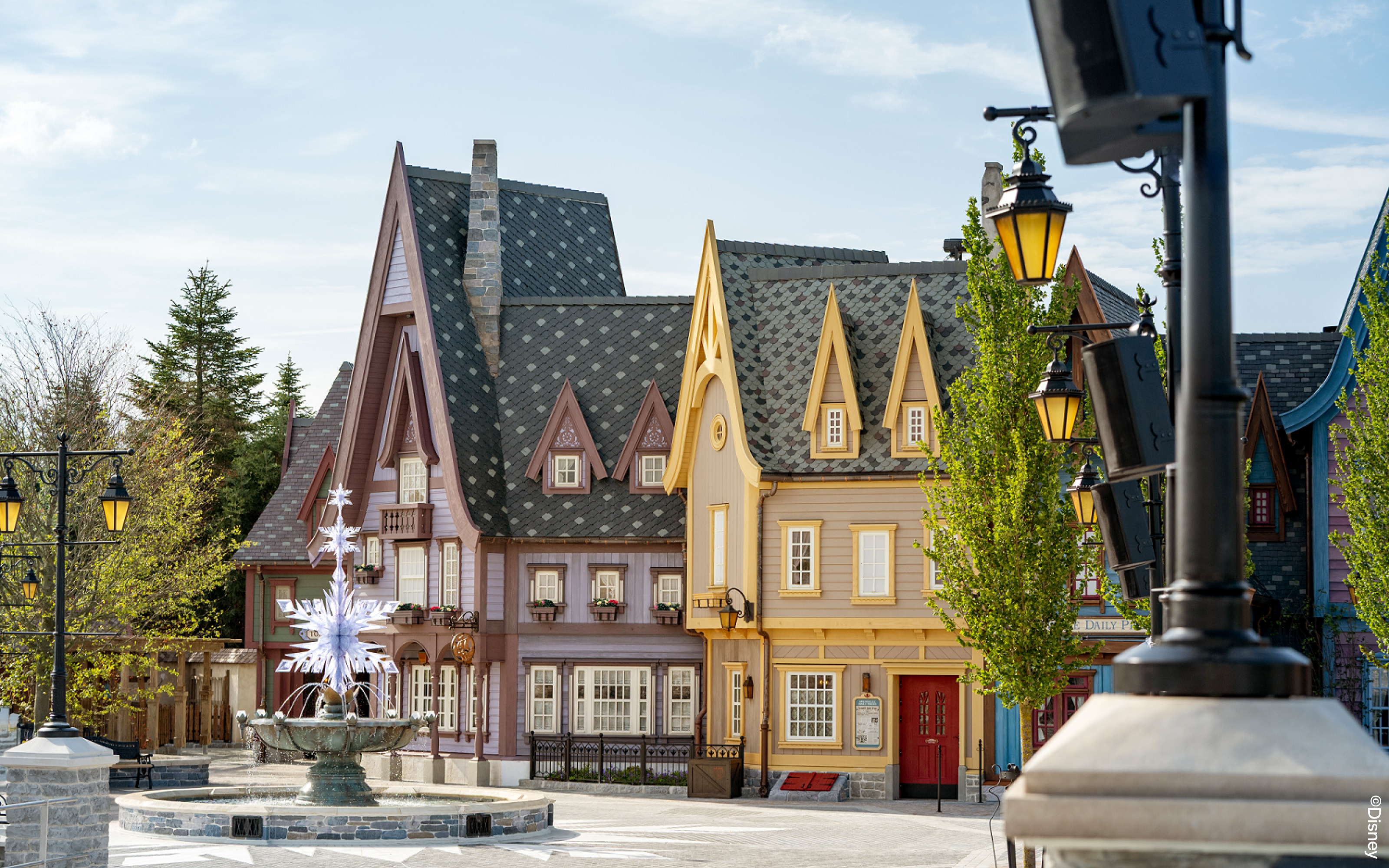 Charming village scene with colorful buildings and a decorative fountain at Disneyland Paris.