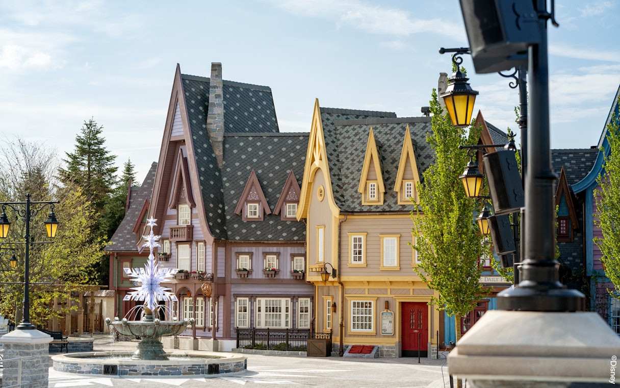 Charming village scene with colorful buildings and a decorative fountain at Disneyland Paris.