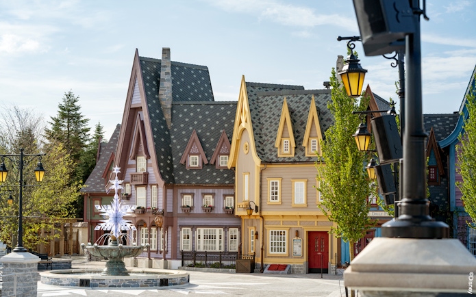 Charming village scene with colorful buildings and a decorative fountain at Disneyland Paris.