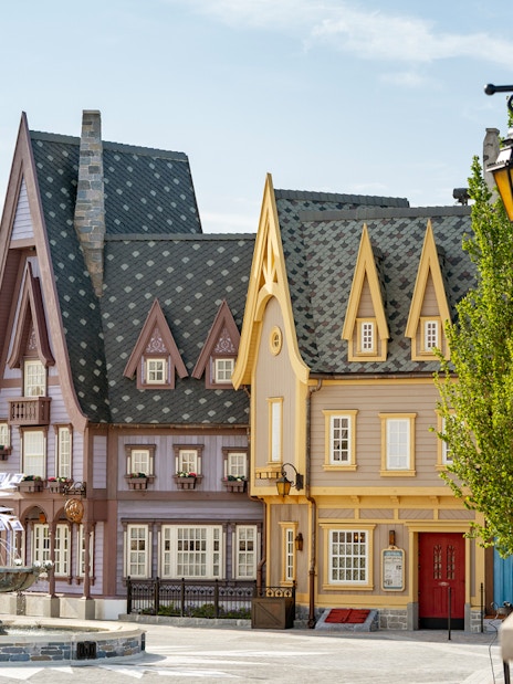 Charming village scene with colorful buildings and a decorative fountain at Disneyland Paris.