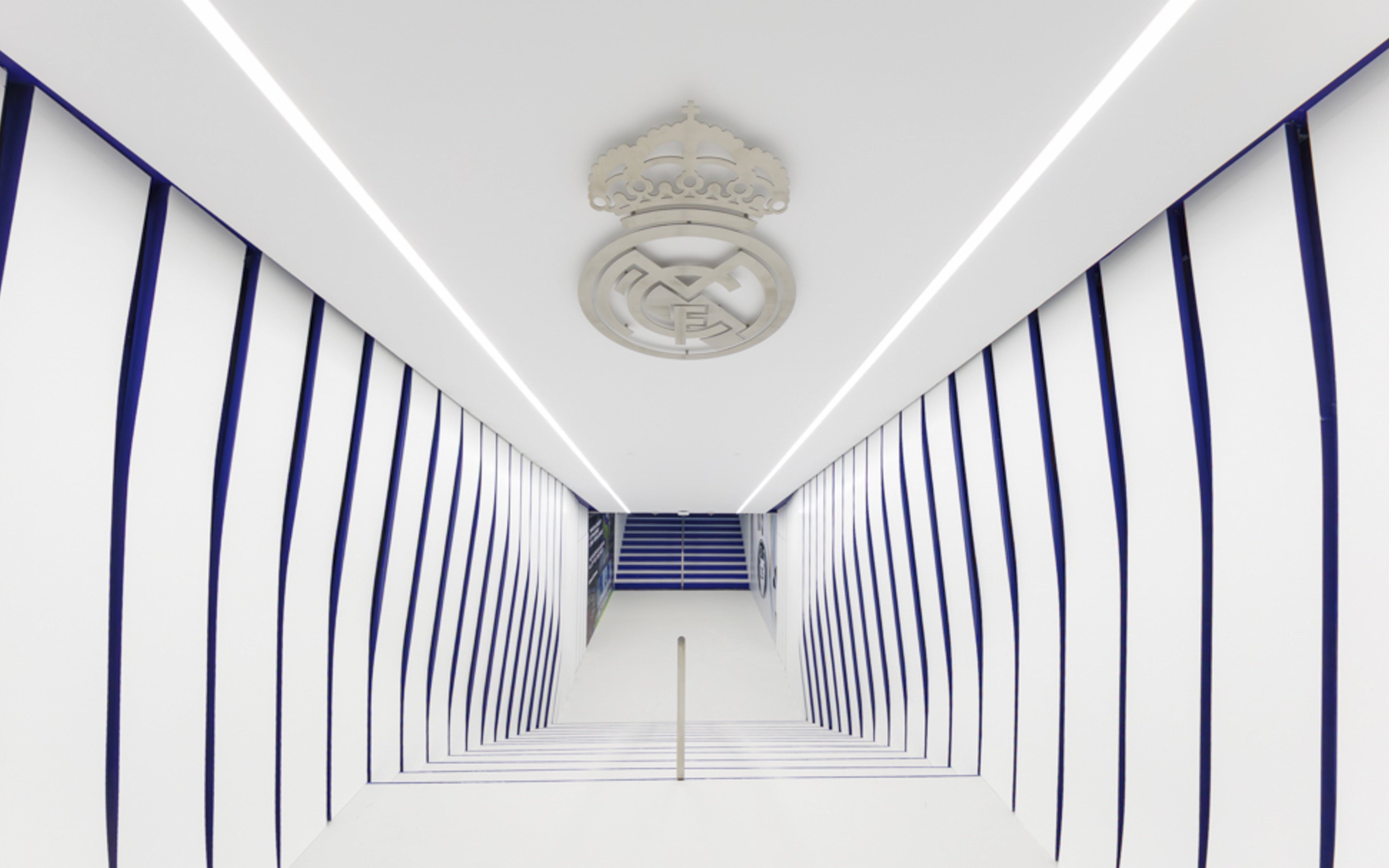 Player tunnel at Santiago Bernabéu Stadium with team emblem on ceiling.