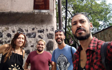 Group exploring historic stone wall in Mexico City on self-guided tour.
