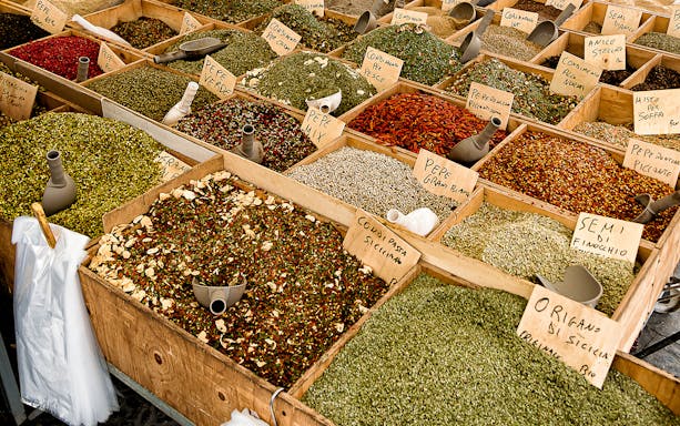 Ortigia market scene with fresh produce and seafood, highlighting a cooking class experience in Siracusa, Italy.