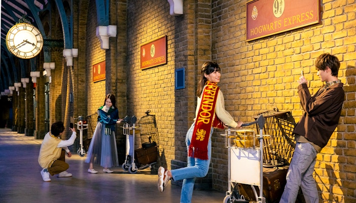 Visitors exploring Platform 9 3/4 at Warner Bros. Studio Tour Tokyo, featuring iconic Harry Potter elements.