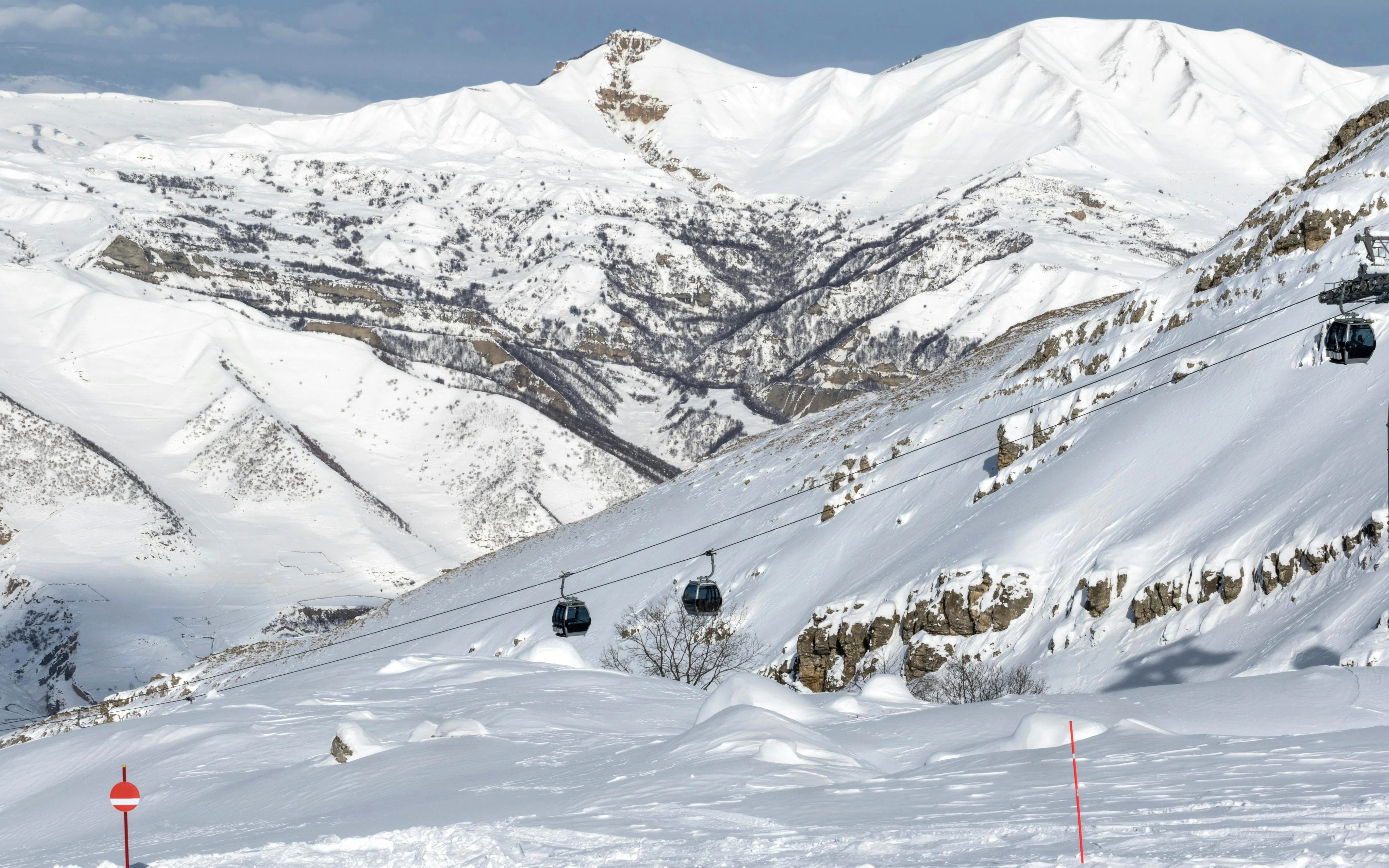 Gondola lift over snow-covered ski slope in Shahdag, Azerbaijan mountains.