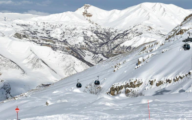 Gondola lift over snow-covered ski slope in Shahdag, Azerbaijan mountains.