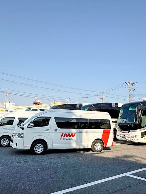 Kansai Airport shuttle vans and buses in parking lot for hotel drop-off service.