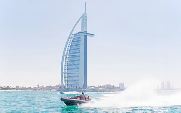 Tourist driving self-drive boat near Burj Al Arab in Dubai.